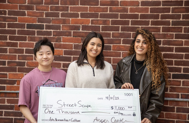 My teammates and I holding a check award for our project